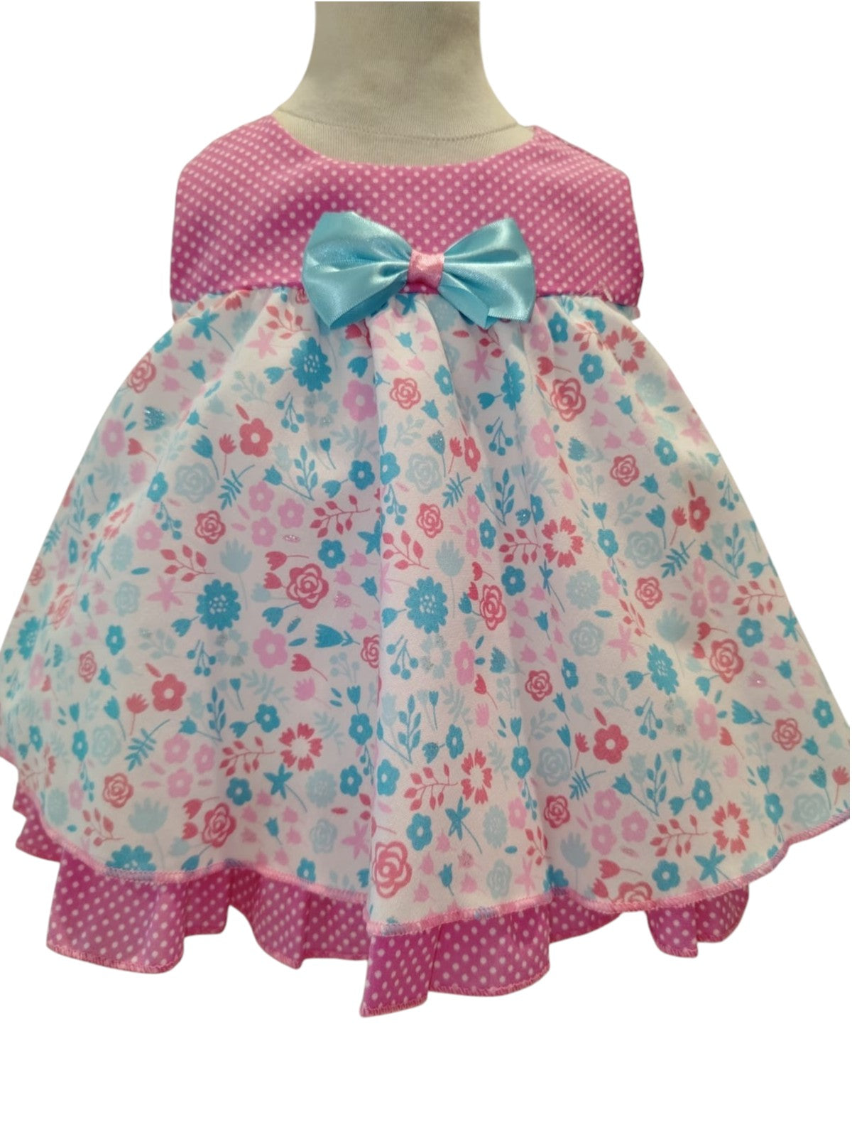Peques pink and blue floral print cotton dress with white polka dot bodice and ruffle hem. Light blue bow accent.