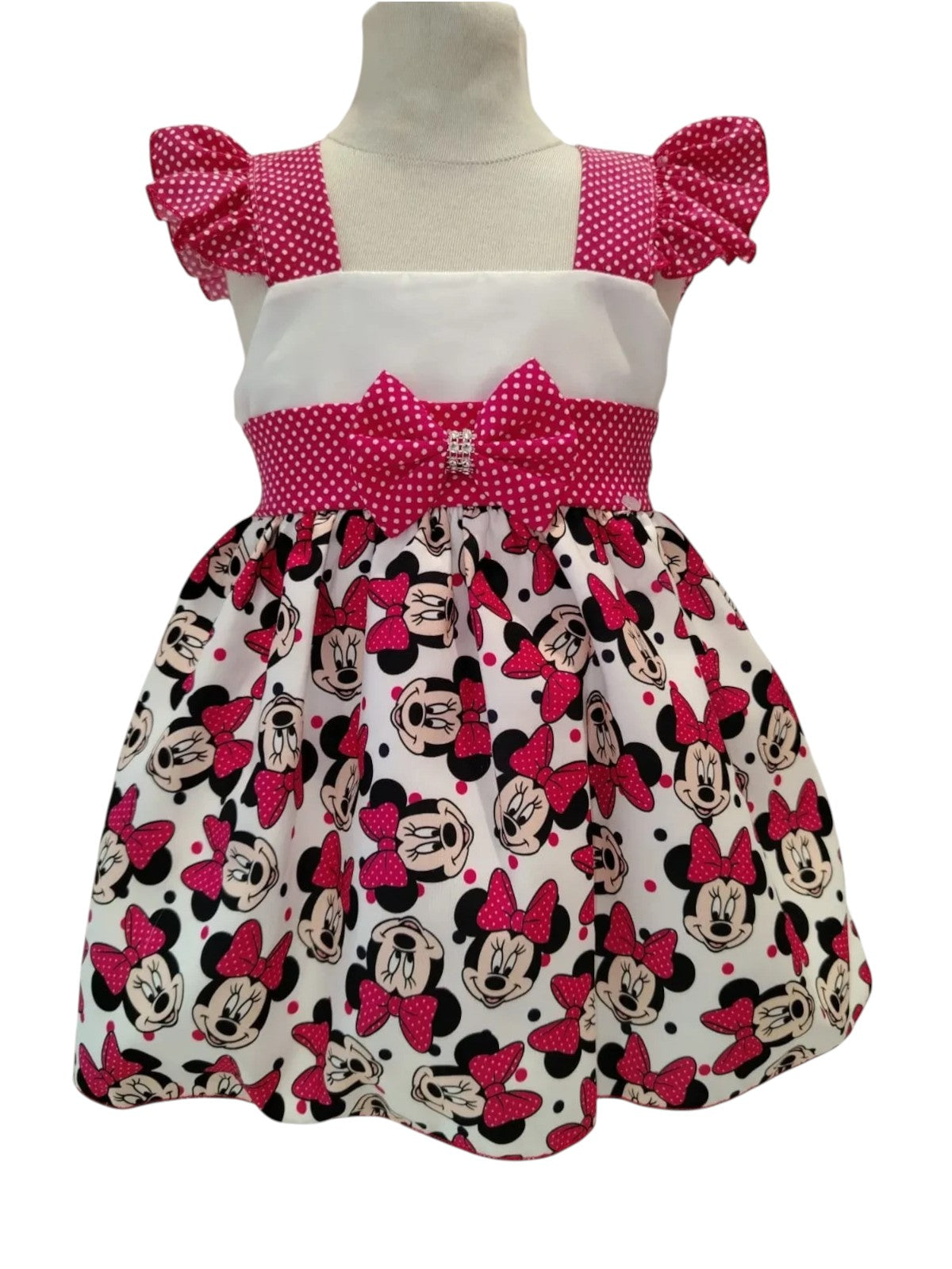 Peques baby girl's white dress with Minnie Mouse print, pink polka dot bodice, and puffed sleeves.